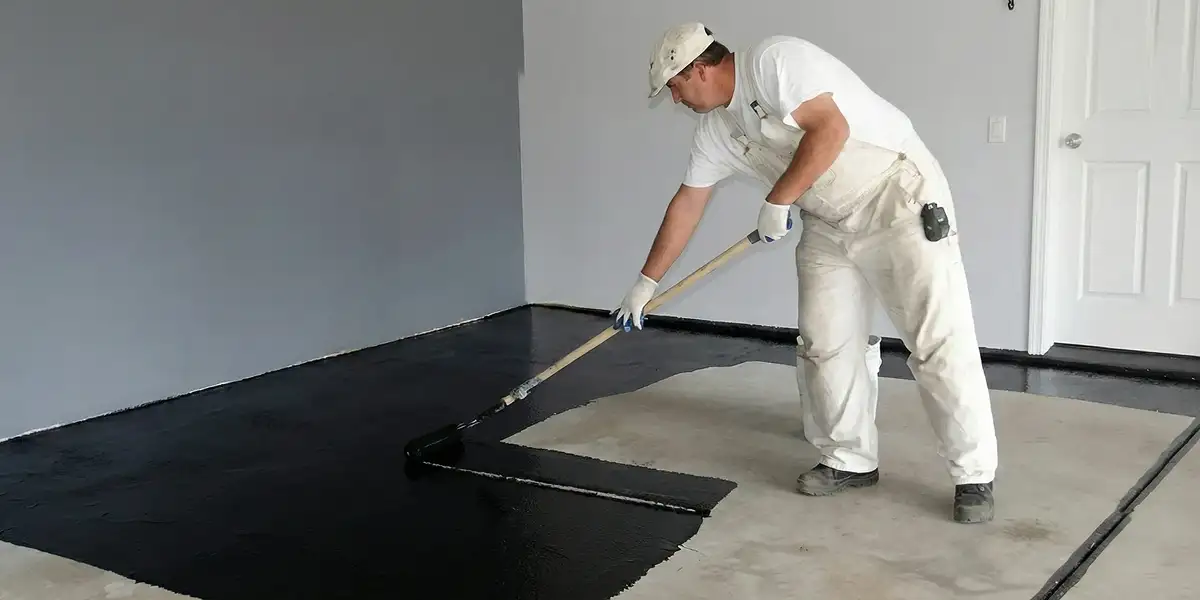 basement waterproofing professional applying waterproof coating to protect a basement floor in Oklahoma City, OK