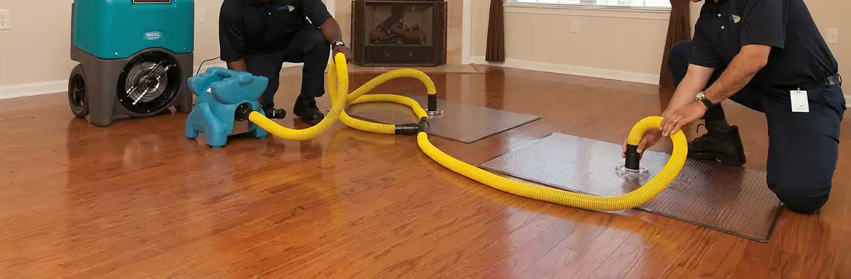 emergency water removal technicians extracting standing water from a home using professional equipment in Oklahoma City, OK